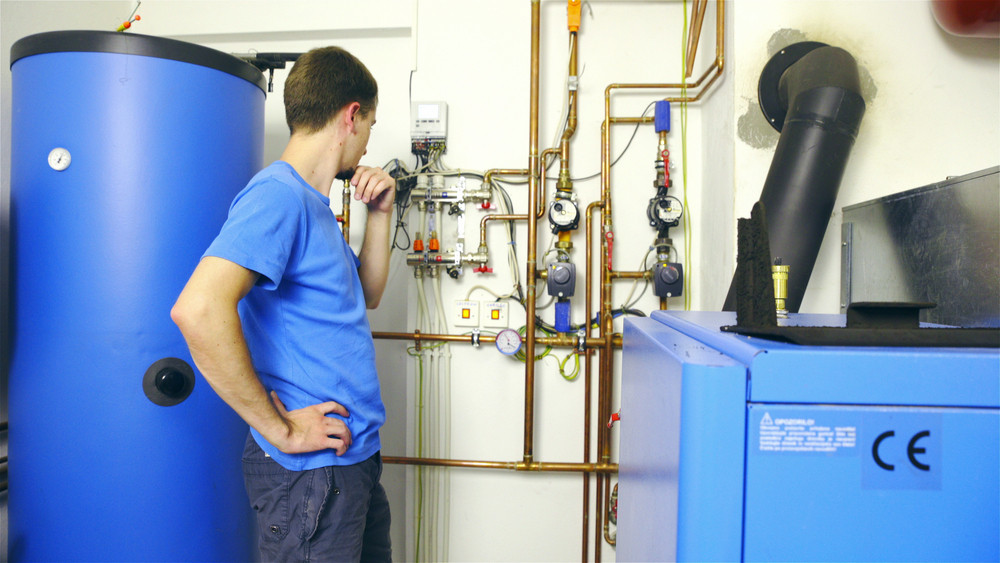 Technician performing water heater repair on a tankless unit
